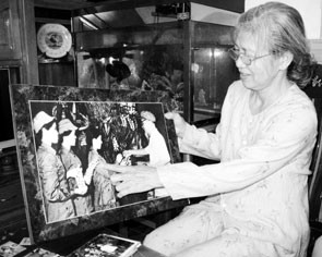 Bà Buổi bên bức ảnh kỷ niệm.