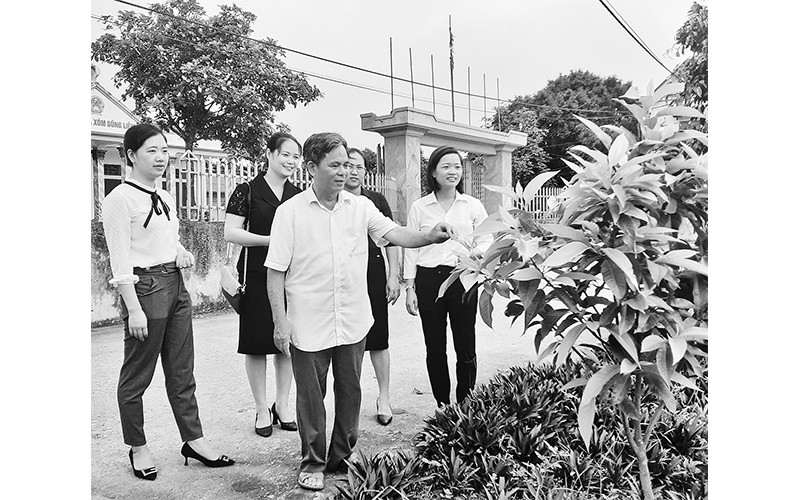 Cán bộ, đảng viên cùng người dân thôn Ô Mễ, xã Tràng An, huyện Bình Lục kiểm tra chất lượng các công trình đường hoa, cây cảnh.