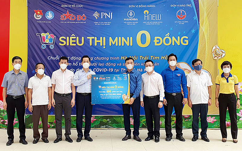 Đại diện Ban Tổ chức “Siêu thị mini 0 đồng” trao 800 phiếu mua hàng tặng đại diện chính quyền quận Hoàn Kiếm.