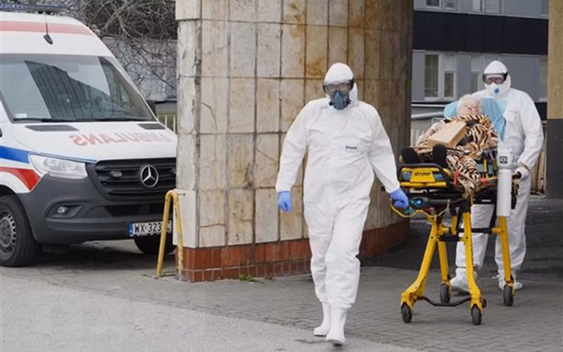 Nhân viên y tế chuyển bệnh nhân Covid-19 vào bệnh viện ở Warsaw, Ba Lan. (Ảnh: AFP/TTXVN)