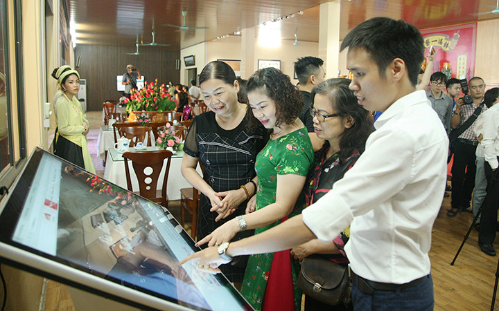 Du khách sử dụng ứng dụng công nghệ để tìm hiểu về nghề gốm truyền thống ở Bát Tràng (Hà Nội). Ảnh: GIANG DŨNG