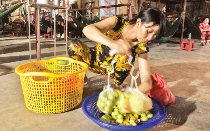 Chị Loan soạn lại rổ trái cây, chuẩn bị cho buổi bán dạo.