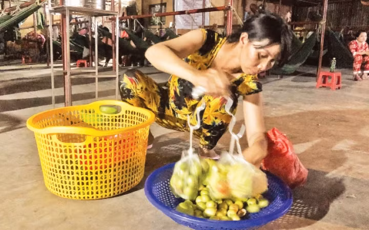 Chị Loan soạn lại rổ trái cây, chuẩn bị cho buổi bán dạo.
