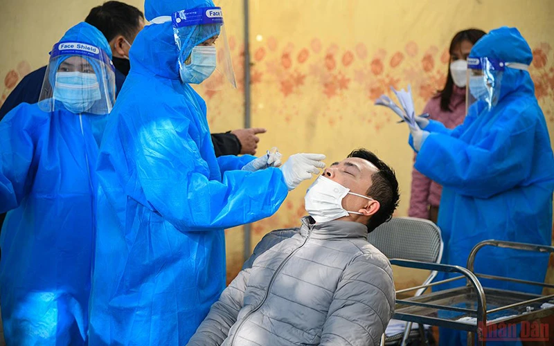 Nhân viên y tế quận Hoàng Mai lấy mẫu xét nghiệm Covid-19 cho các F0 tại Nhà văn hóa phường Hoàng Liệt. (Ảnh: THÀNH ĐẠT) 