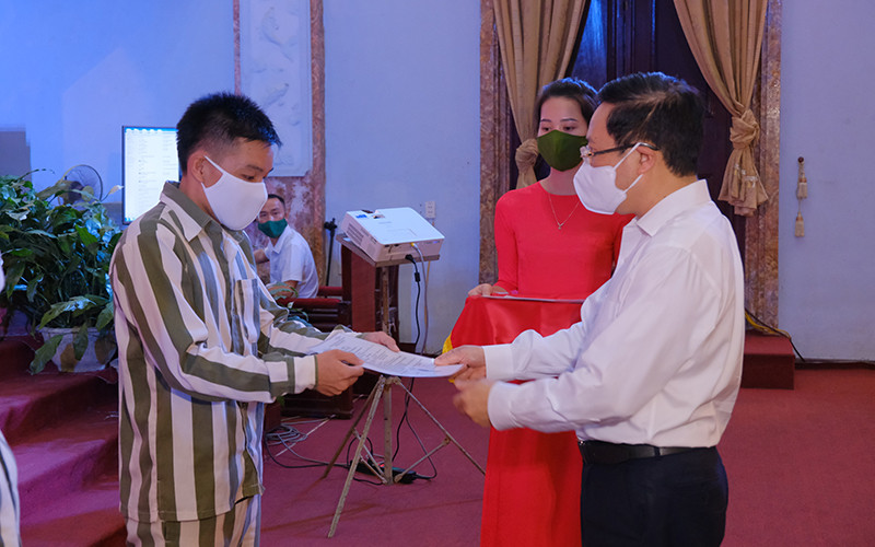 Đồng chí Phạm Bình Minh, Uỷ viên Bộ Chính trị, Phó Thủ tướng Chính phủ, Chủ tịch Hội đồng Tư vấn đặc xá trao Giấy chứng nhận đặc xá cho phạm nhân.