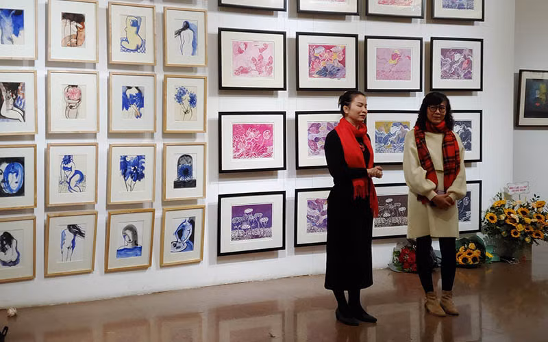 Hai nữ họa sĩ Trang Thanh Hiền và Nguyễn Mỹ Ngọc giới thiệu các tác phẩm tại triển lãm “Mùa trong vườn”. (Ảnh: Thế Sơn)