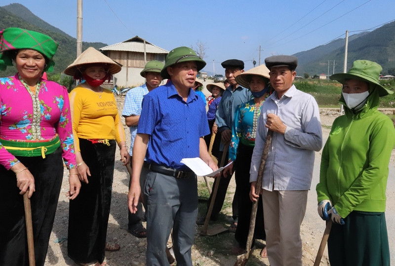 Ông Lò Văn Pháng (đứng giữa áo xanh) vận động người dân làm đường giao thông nông thôn.
