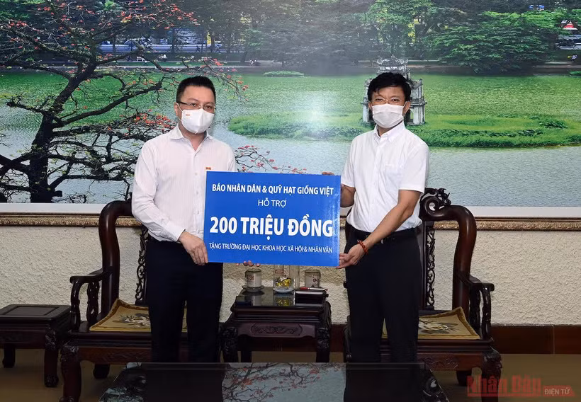 Đồng chí Lê Quốc Minh, Tổng Biên tập Báo Nhân Dân trao quà hỗ trợ Trường đại học Khoa học Xã hội và Nhân văn. Ảnh: DUY LINH