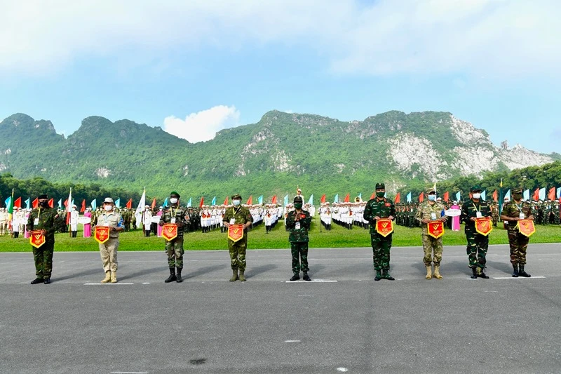 Đại diện Ban Tổ chức trao cờ lưu niệm tặng các Đoàn tuyển thủ quân đội các nước tham dự.