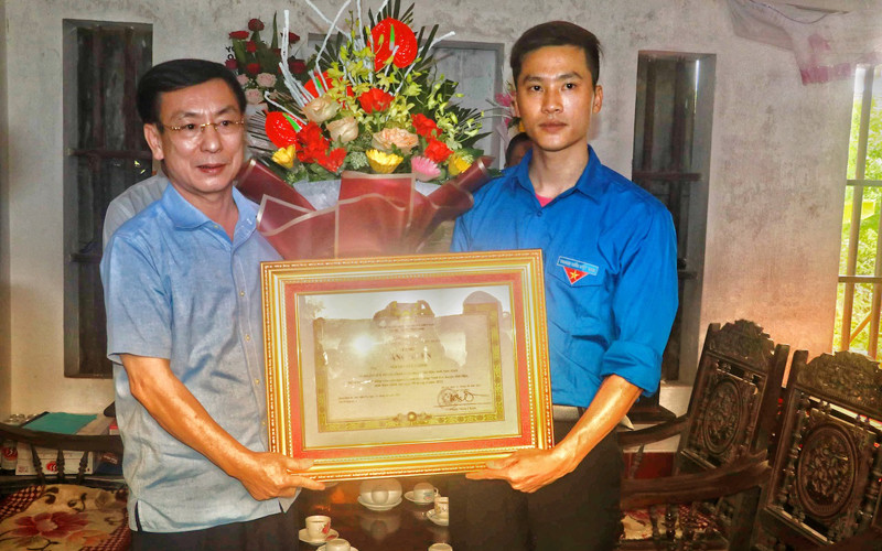 Chủ tịch UBND tỉnh Nam Định Phạm Đình Nghị trao cho anh Nguyễn Đức Chính Bằng khen của Thủ tướng Chính phủ vì hành động dũng cảm cứu người.