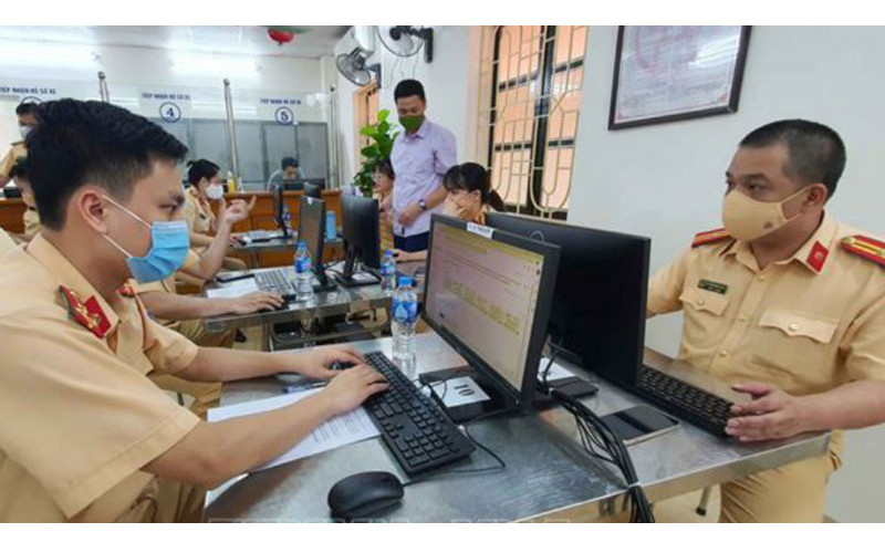 Cán bộ Phòng Cảnh sát giao thông Hà Nội cấp giấy đi đường cho người dân. (Ảnh: Chu Dũng)