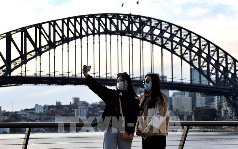 Du khách chụp ảnh tại khu vực Cầu Cảng Sydney, Australia. (Ảnh: AFP/TTXVN)
