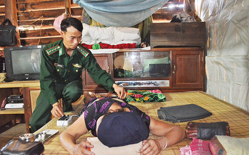 Đại úy, bác sĩ Hoàng Ngọc Linh điều trị cho bà Hom bằng phương pháp châm cứu.Ảnh | Ngọc Lân