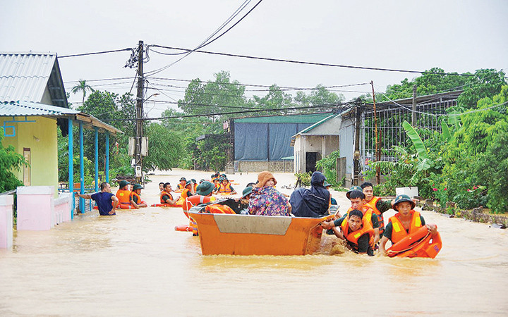 Cán bộ, chiến sĩ LLVT Quân khu 4 dầm mình trong mưa lũ giúp dân. Ảnh | Tâm Quang