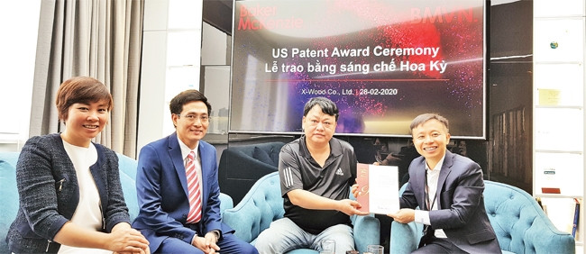 Trần Hoài Nam nhận bằng sáng chế từ luật sư Trần Mạnh Hùng.