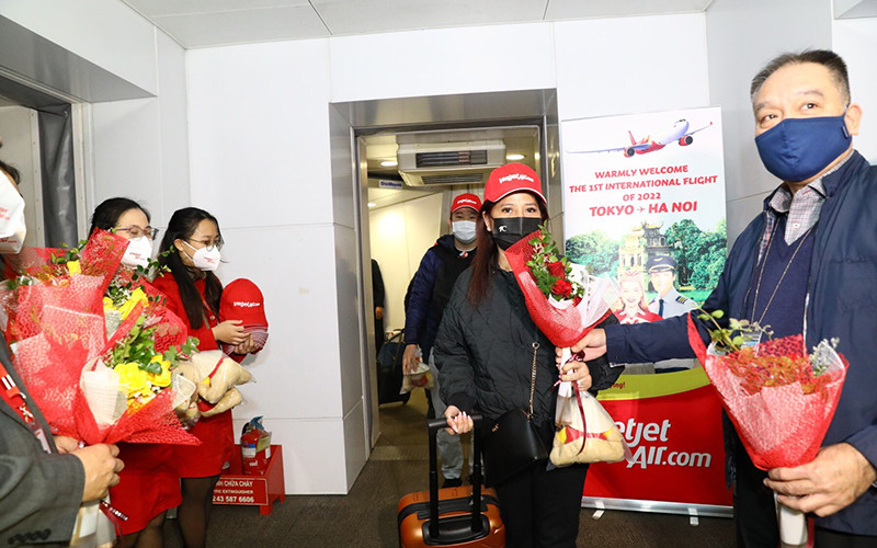 Lãnh đạo Cục Hàng không tặng hoa cho hành khách trên chuyến bay. (Ảnh: Hãng hàng không Vietjet cung cấp)