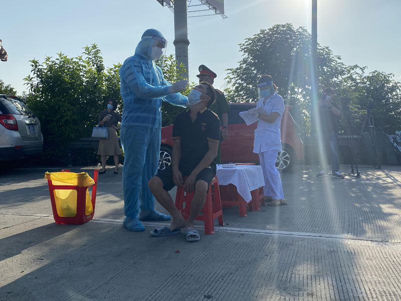 Lực lượng y tế tiến hành lấy mẫu test nhanh tại chỗ với lái xe từ tỉnh Hà Nam đi vào Hà Nội.