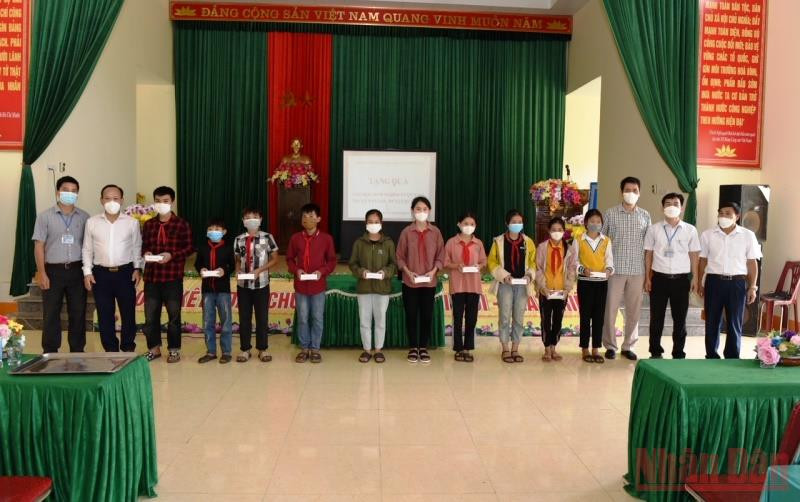 Đại diện lãnh đạo huyện Quỳ Hợp và phóng viên Báo Nhân Dân thường trú tại Nghệ An trao điện thoại thông minh cho các cháu học sinh nghèo hiếu học. 