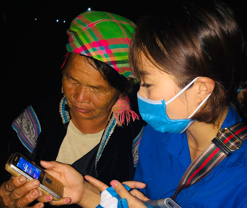Tình nguyện viên hướng dẫn cài đặt ứng dụng Bluezone cho một người dân ở Lai Châu.
