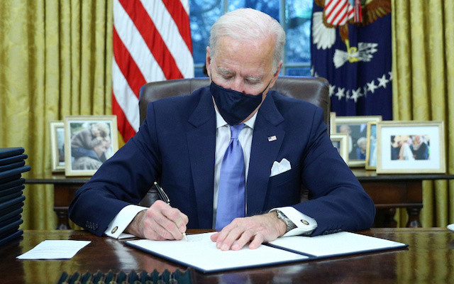 Tổng thống Mỹ Joe Biden ký các sắc lệnh tại phòng Bầu Dục của Nhà Trắng, ở Washington, Mỹ, sau khi ông tuyên thệ nhậm chức ngày 20-1-2021. (Ảnh: Reuters)