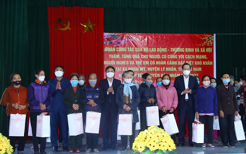 Bộ trưởng Đào Ngọc Dung, lãnh đạo tỉnh Hà Nam tặng quà gia đình chính sách, hộ nghèo tại chương trình. (Ảnh: Molisa)