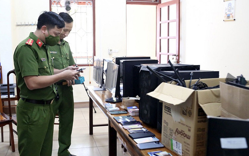 Cơ quan Cảnh sát điều tra Công an huyện Lộc Hà (tỉnh Hà Tĩnh) lập biên bản tạm giữ tang vật trong đường dây đánh bạc trực tuyến qua ví điện tử. (Ảnh Hùng Nga)