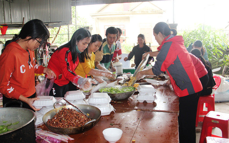 Hàng chục nghìn suất cơm miễn phí được chị em phụ nữ chế biến, vận chuyển vào tâm lũ.