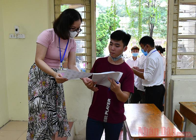 Cán bộ coi thi kiểm tra thông tin thí sinh tại Kỳ thi tốt nghiệp THPT 2020. ẢNh: THUỶ NGUYÊN