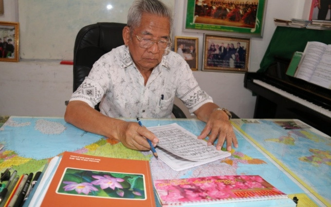 Nghệ sĩ Douangmixay Likaya bên bản thảo ca khúc "Mặt trời soi sáng bản Xiengvang".