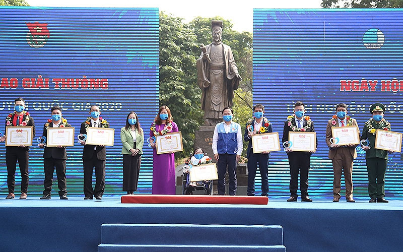 Đồng chí Nguyễn Anh Tuấn (áo xanh, đứng giữa trong ảnh) trao Bằng khen tặng các tình nguyện viên có cống hiến xuất sắc trong năm vừa qua.