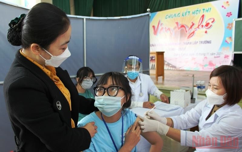 Giáo viên Trường THPT Quảng Xương 1 động viên học sinh tiêm chủng phòng Covid-19. (Ảnh: MAI LUẬN)