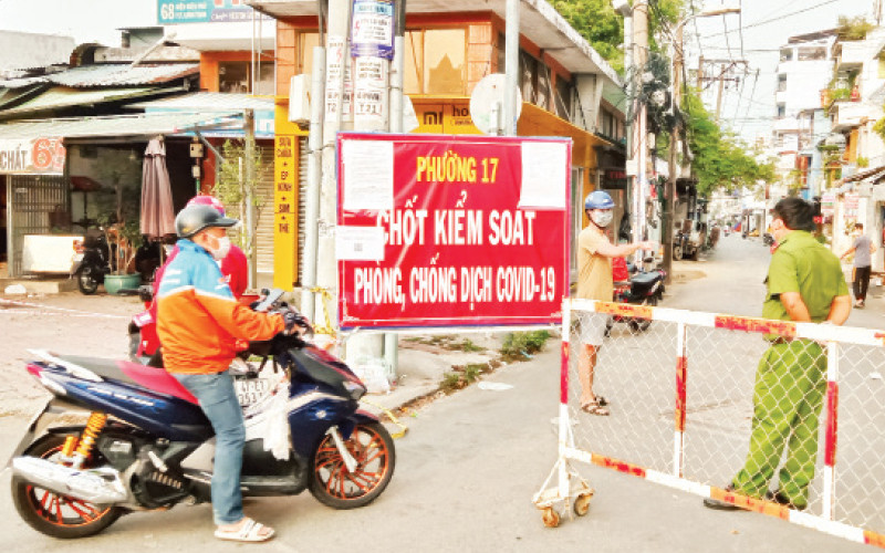 Lực lượng chức năng dựng chốt kiểm tra lượng người ra vào phường 17, quận Bình Thạnh.