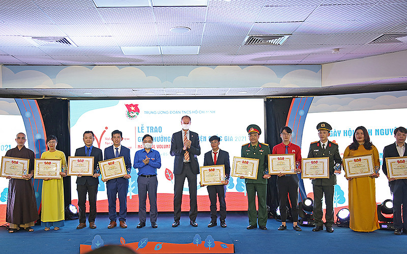 Đồng chí Nguyễn Anh Tuấn và ông Patrick Haverman, Phó Trưởng Đại diện Liên hợp quốc tại Việt Nam (thứ 5 và 6 từ trái sang trong ảnh) trao Giải thưởng Tình nguyện quốc gia năm 2021 tặng các câu lạc bộ, đội, nhóm tình nguyện tiêu biểu.
