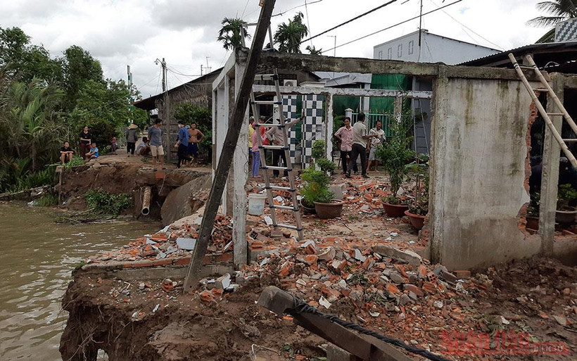 Một hộ dân đã tự di dời nhà sau khi bờ sông và sân nhà đã bị nước nhấn chìm xuống sông vào rạng 2-8.