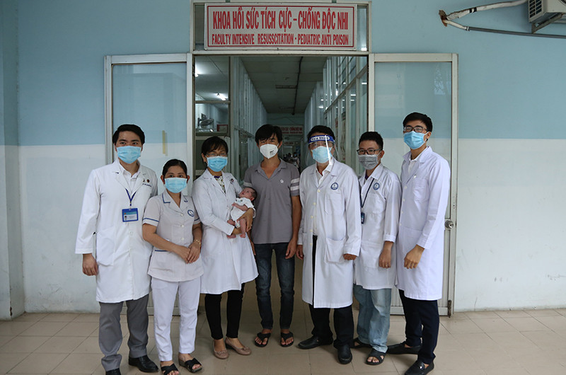 Các bác sĩ của ê-kíp trực tiếp cứu sống bệnh nhi chụp ảnh cùng với cha và bé.