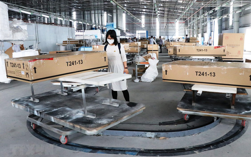 Đóng gói và kiểm tra lô hàng đồ gỗ xuất khẩu sang thị trường Mỹ tại Công ty Triệu Phú Lộc (Bình Dương). (Ảnh: TTXVN)