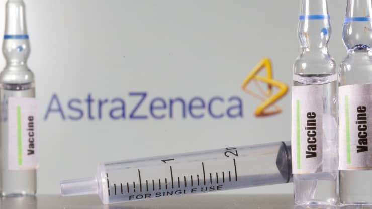 Một ống nghiệm dán nhãn vaccine được nhìn thấy phía trước logo AstraZeneca được chụp vào ngày 9-9-2020. Ảnh: Reuters.