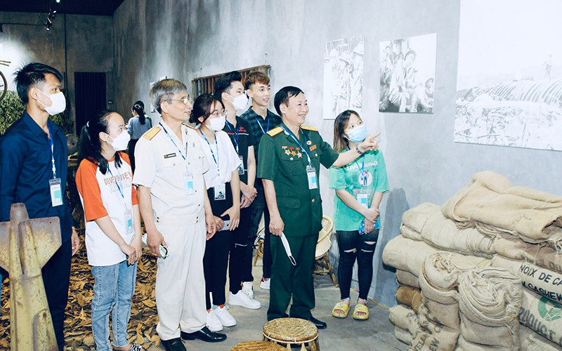 Các cựu chiến binh, các em học sinh tham quan triển lãm.