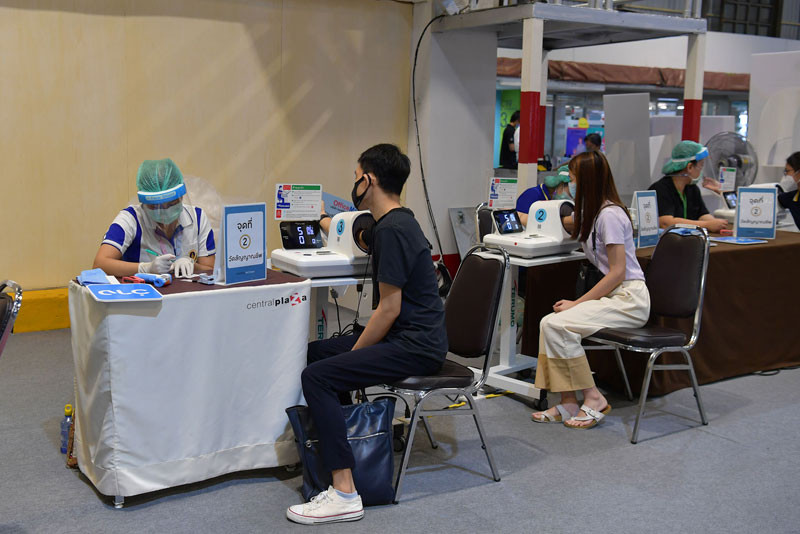 Một người dân đang kiểm tra sức khỏe trước khi được tiêm vaccine ngừa Covid-19 tại Bangkok. (Ảnh: NAM ĐÔNG)