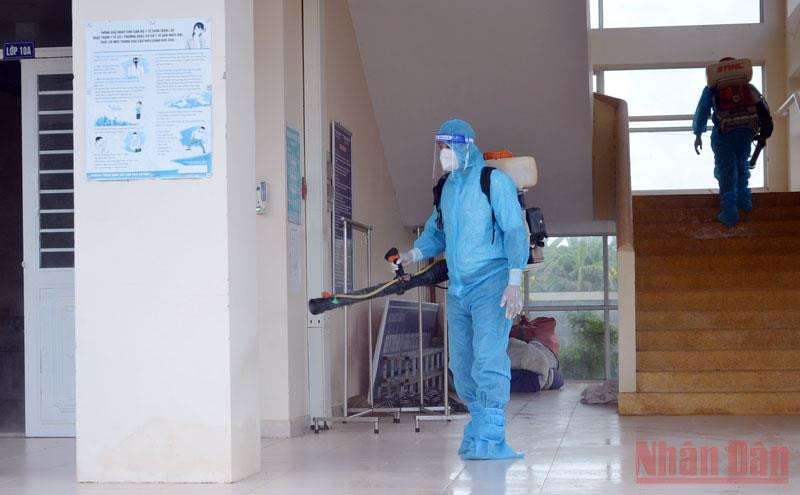 Nhân viên y tế phun hóa chất khử khuẩn trường học.