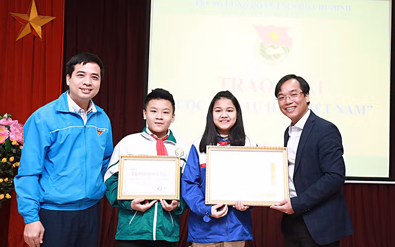 Đồng chí Nguyễn Bình Minh, Trưởng Ban Tổ chức Cuộc thi (ngoài cùng bên phải) trao giải nhất tặng nhóm tác giả Lương Thanh Thảo - Lương Đức Hiếu.