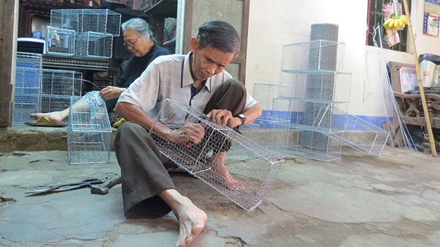 Vợ chồng ông Lục đang lắp ráp lồng bẫy chuột.