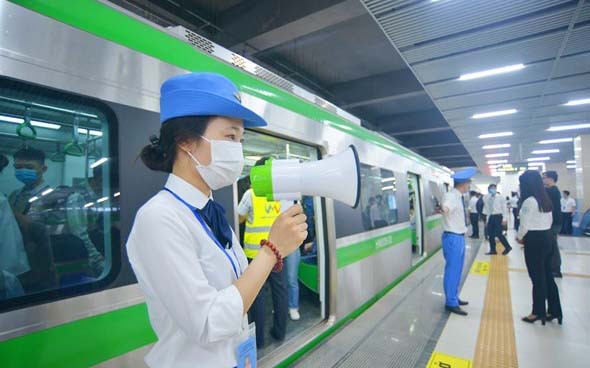 Nhân viên tàu điện Cát Linh-Hà Đông hướng dẫn hành khách mua vé và bảo đảm trật tự trước khi lên tàu.