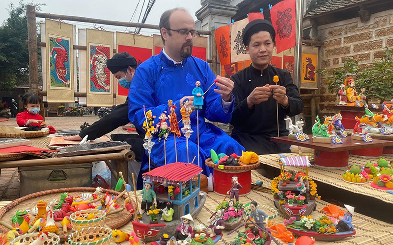 Khách du lịch quốc tế tham gia hoạt động trải nghiệm văn hóa ở làng cổ Đường Lâm, xã Đường Lâm, thị xã Sơn Tây (Hà Nội).