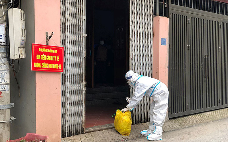 Nhân viên trạm y tế lưu động phường Đống Đa (thành phố Vĩnh Yên, tỉnh Vĩnh Phúc) thu gom rác thải từ gia đình có F0 điều trị tại nhà. (Ảnh LÊ MƠ)