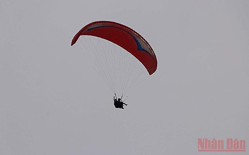 Du khách trải nghiệm bay dù lượn tại lễ khai mạc.