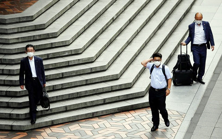 Người dân chấp hành quy định đeo khẩu trang tại Tô-ki-ô, Nhật Bản. Ảnh ROI-TƠ