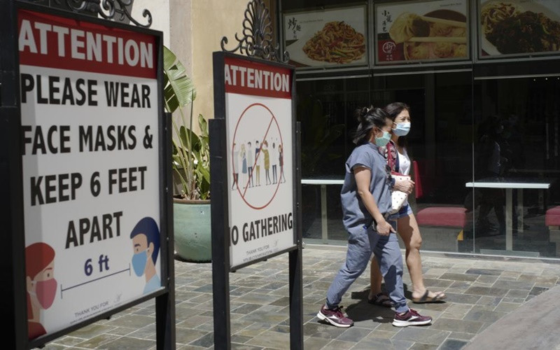 Người dân tại Los Angeles, Mỹ đeo khẩu trang khi ra ngoài. (Ảnh: AP)