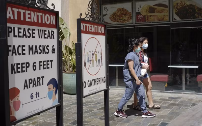 Người dân tại Los Angeles, Mỹ đeo khẩu trang khi ra ngoài. (Ảnh: AP)