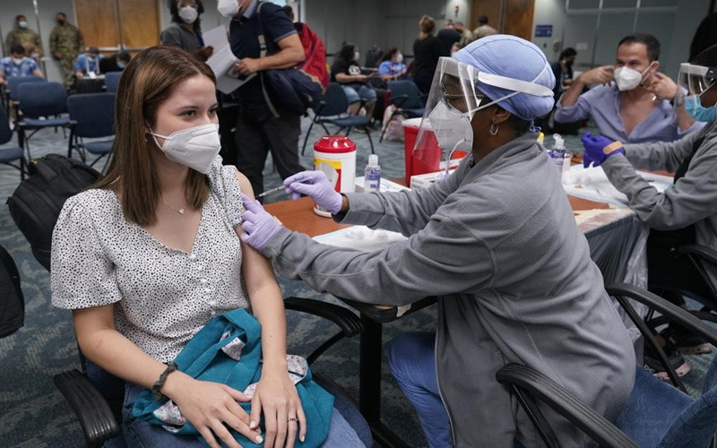 Cô Natalia Dubom (Honduras) được tiêm vaccine ngừa Covid-19 khi tới Sân bay quốc tế Miami, tại Miami, Mỹ. (Ảnh: AP)